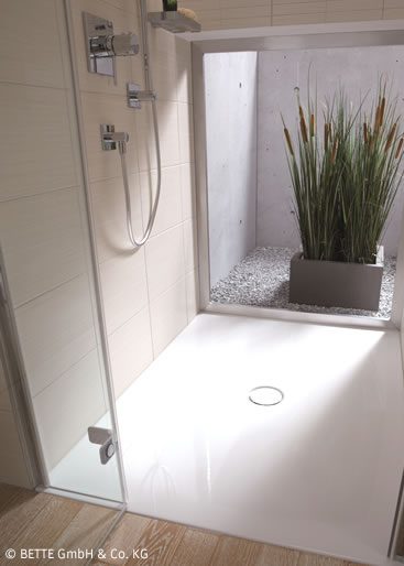 Barrierefreie Dusche Moderne Dusche mit grauem Boden, Pflanze und großer Glasfront. Einladend und hell. Barrierefrei